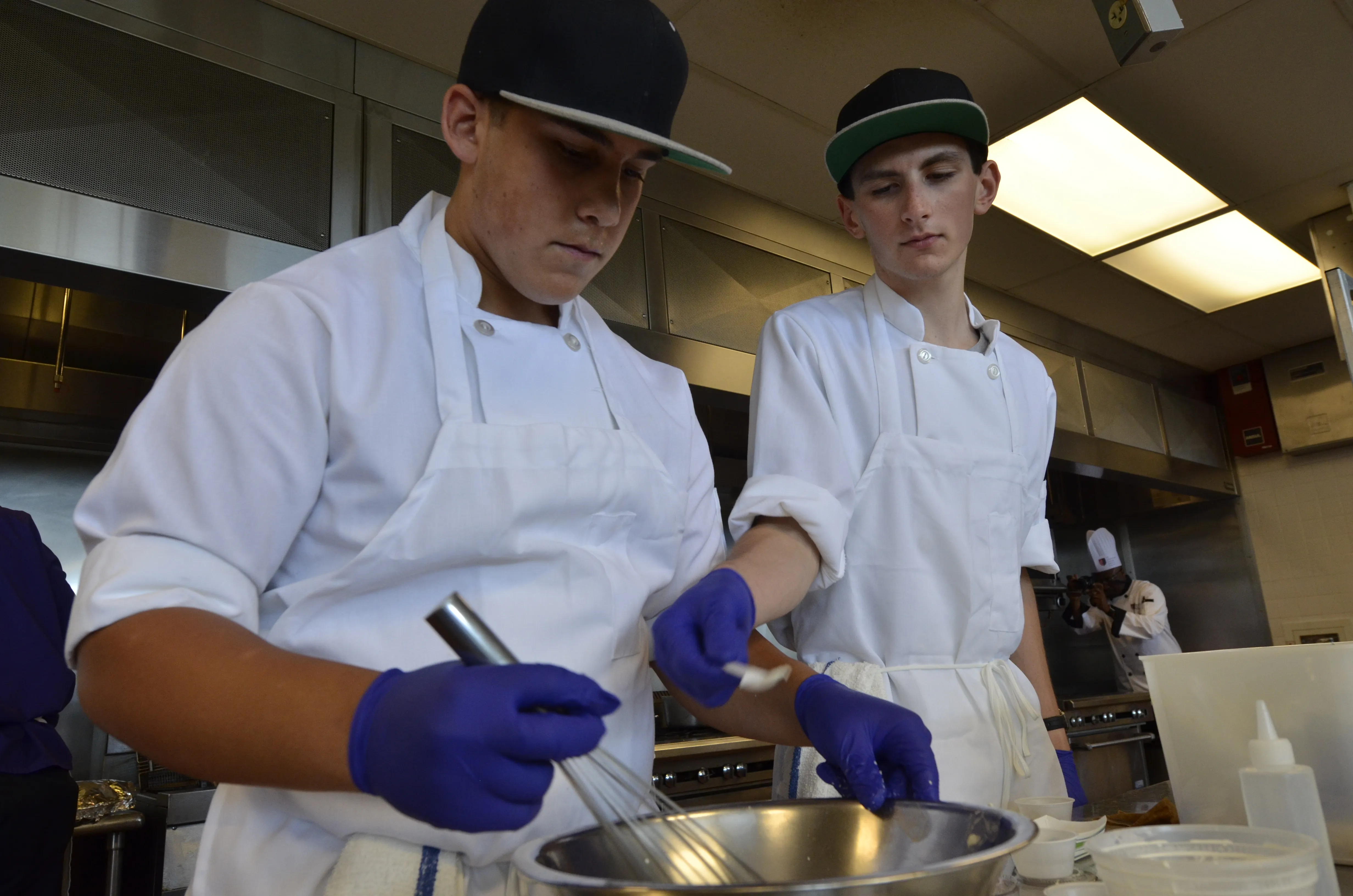 students in chef coats cooking